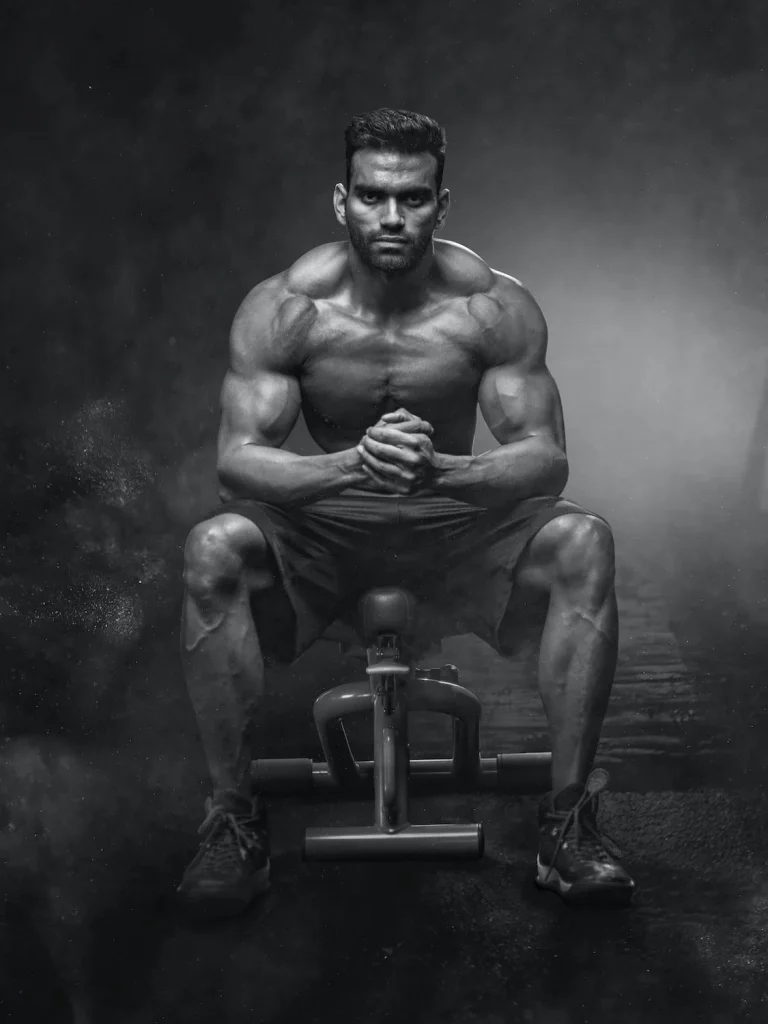 grayscale photo of man sitting on bench